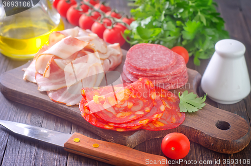 Image of sausages,ham and salami on board