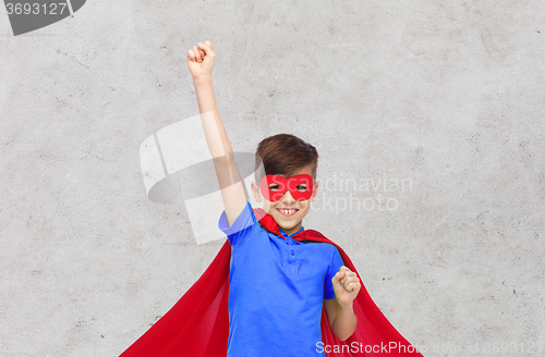 Image of boy in red superhero cape and mask showing fists