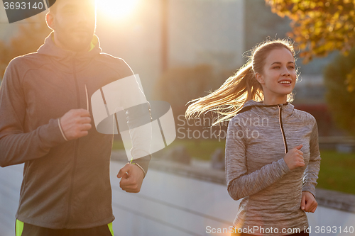 Image of happy couple running outdoors