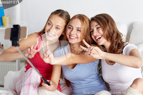 Image of teen girls with smartphone taking selfie at home