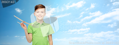 Image of happy boy in green polo t-shirt with toy airplane