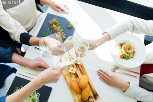 Image of close up of women clinking champagne at restaurant