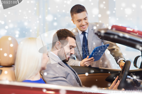 Image of happy couple with car dealer in auto show or salon