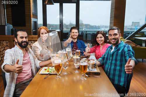 Image of friends dining and drinking beer at restaurant