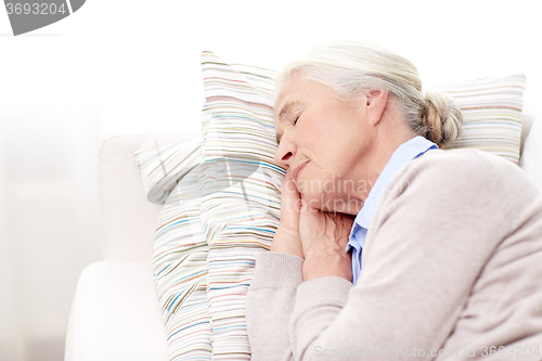 Image of happy senior woman sleeping on pillow at home