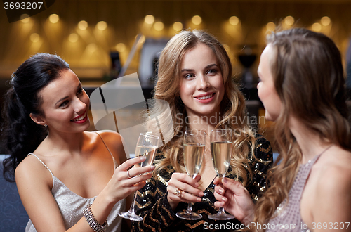 Image of happy women with champagne glasses at night club