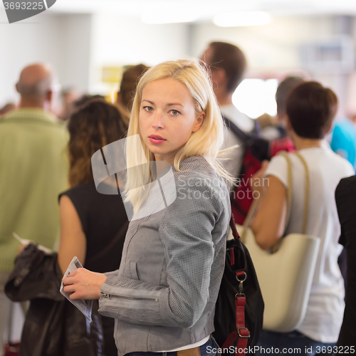 Image of Young blond caucsian woman waiting in line.
