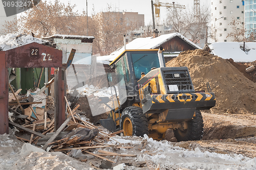 Image of Tractor removes debris from building demolition