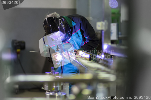 Image of Industrial worker welding in metal factory.