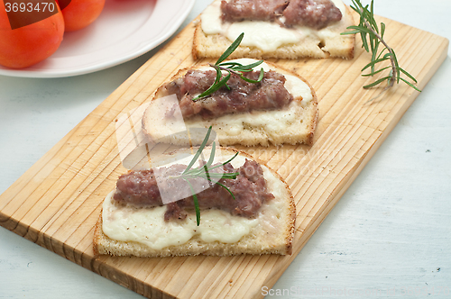 Image of Crispy bruschetta topped with sausage and fresh rosemary