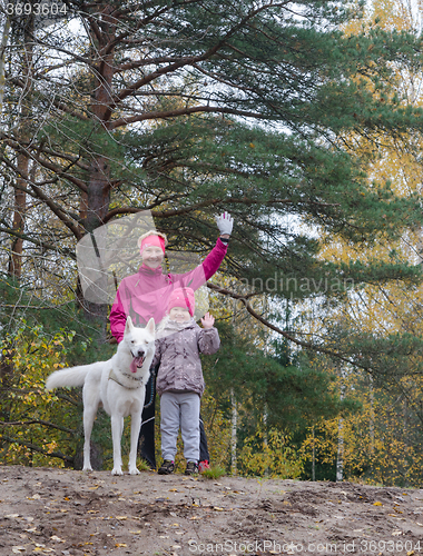 Image of Granny with her granddaughter and a dog walk in Park  