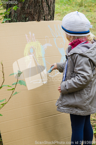 Image of Girl drawing with crayons on cardboard