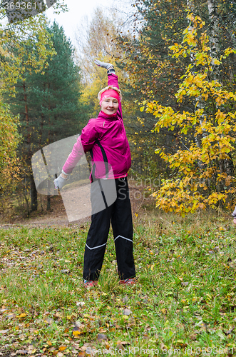 Image of Wman is engaged in aerobics in the autumn park