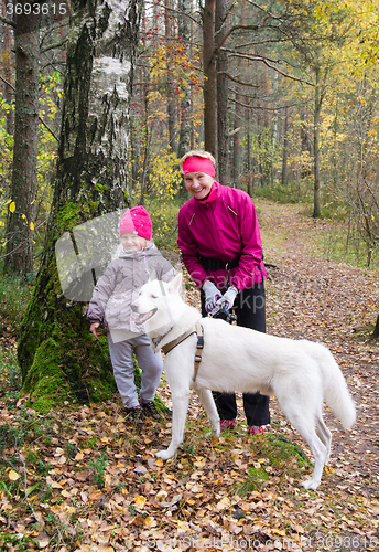 Image of Granny with her granddaughter and a dog walk in Park  