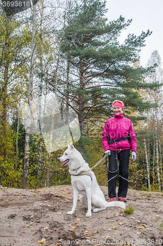 Image of Woman with a white dog in a wood