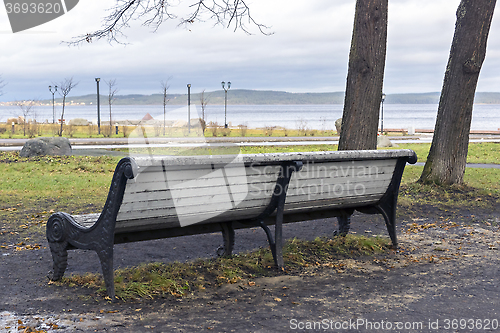 Image of City bench in park in autumn