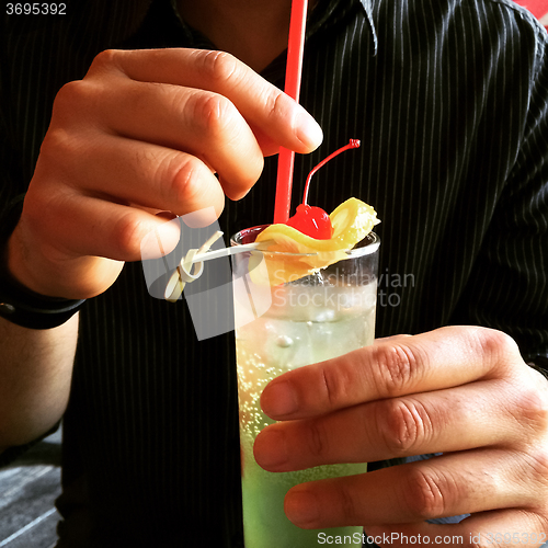 Image of Man holding a glass with cocktail