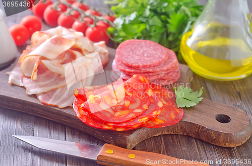 Image of sausages,ham and salami on board