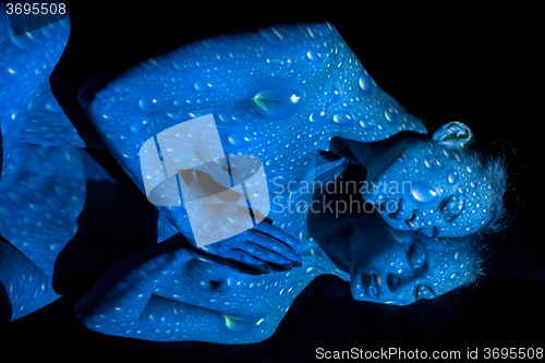 Image of The  body of woman with blue pattern and its reflection