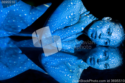 Image of The  body of woman with blue pattern and its reflection