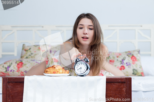 Image of The young girl in bed with  clock service