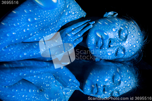 Image of The  body of woman with blue pattern and its reflection