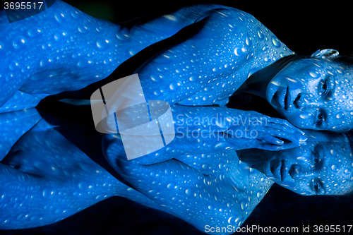 Image of The  body of woman with blue pattern and its reflection