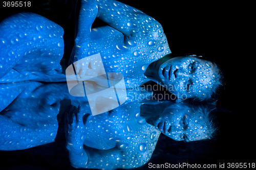 Image of The  body of woman with blue pattern and its reflection