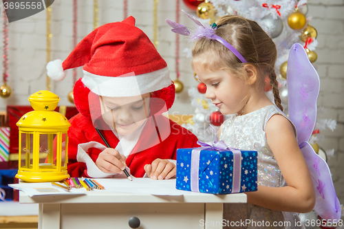 Image of Father Frost wrote a congratulatory letter to the assistant fairy standing next