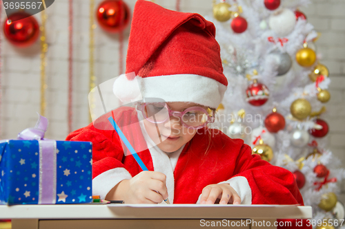 Image of Girl enthusiastically prepares a gift card for Christmas