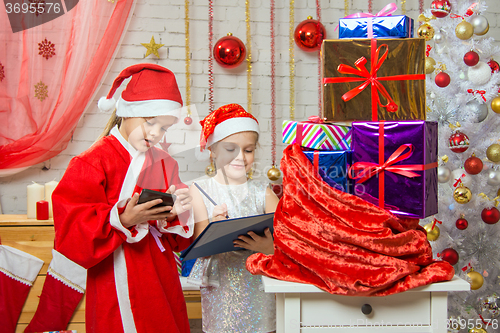 Image of Santa and helper find gifts in a bag