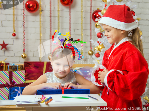 Image of Santa Claus has presented a gift of a happy girl with fireworks on the head