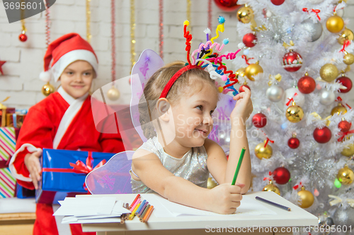 Image of The girl picked up a toy fireworks on the head, Santa Claus sitting behind her