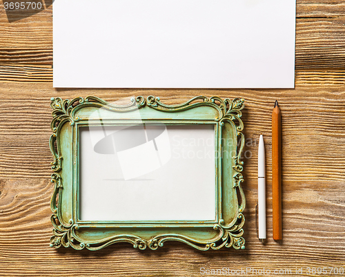 Image of The mockup on wooden background with vintage old picture frame