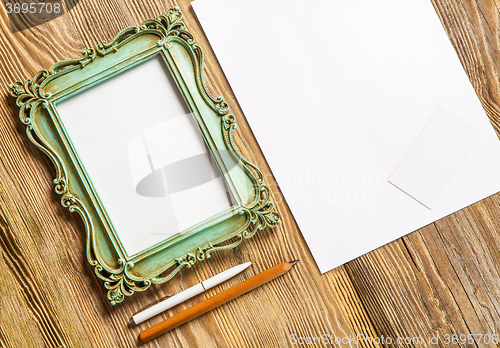 Image of The mockup on wooden background with vintage old picture frame