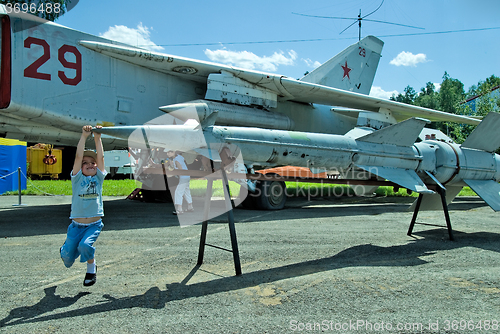 Image of Boy plays with rocket for military airplane