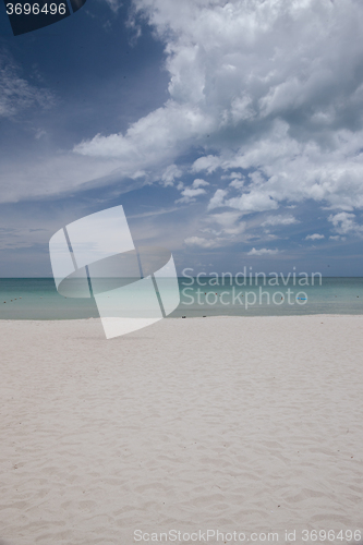 Image of Beach on tropical island. Clear blue water, sand, clouds. 