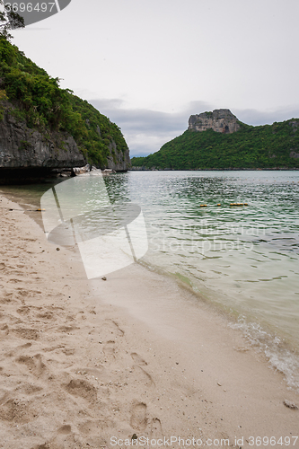 Image of Beach on tropical island. Clear blue water, sand, clouds. 