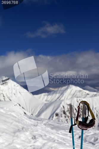 Image of Ski mask on ski poles in snowy mountain