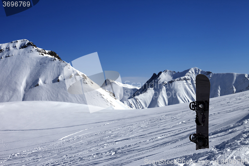 Image of Snowboard in snow on off-piste slope