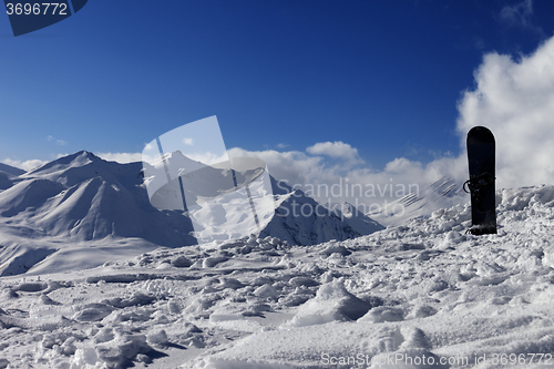 Image of Snowboard in snow on off-piste slope