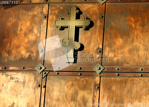 Image of The copper cross on the gate 