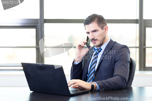 Image of Businessman in office working on laptop computer.