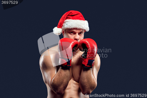 Image of Christmas fitness boxer wearing santa hat boxing on black background