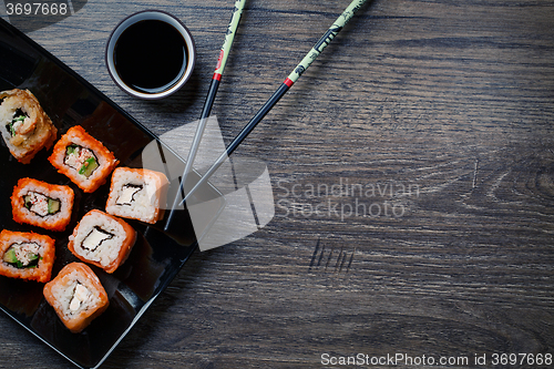 Image of Sushi roll with chopsticks