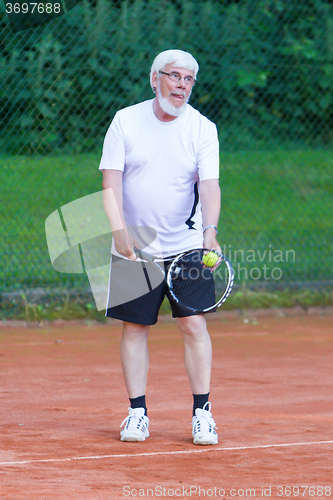 Image of Senior man playing tennis