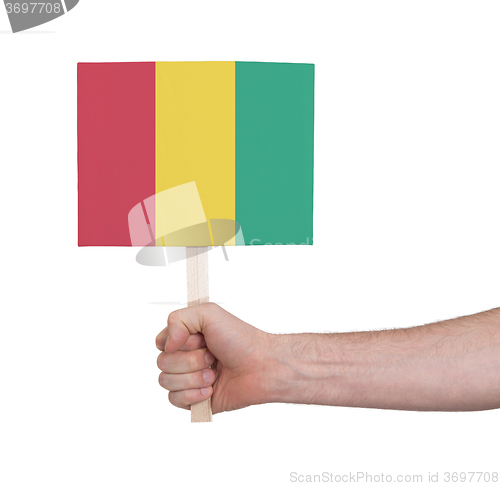 Image of Hand holding small card - Flag of Guinea