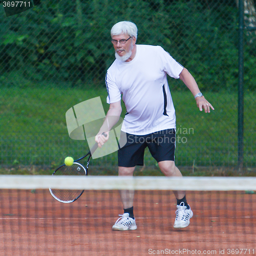 Image of Senior man playing tennis