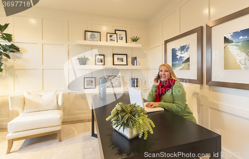 Image of Woman on Phone and Laptop in Office