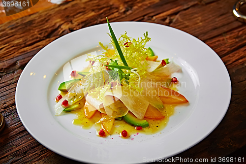 Image of salad of celery, avocado and persimmon with greens 